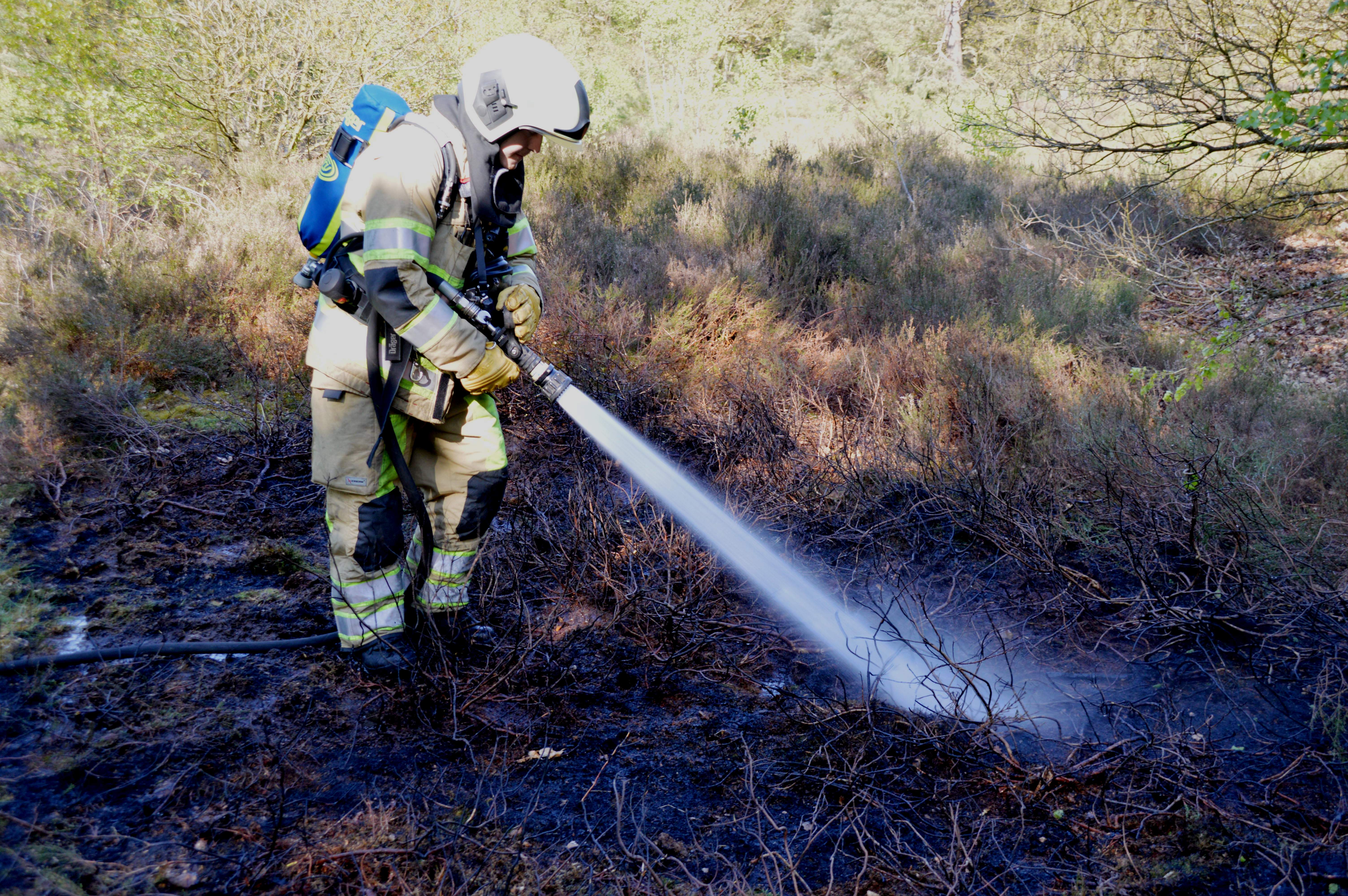 Brandweer blust restanten kampvuur