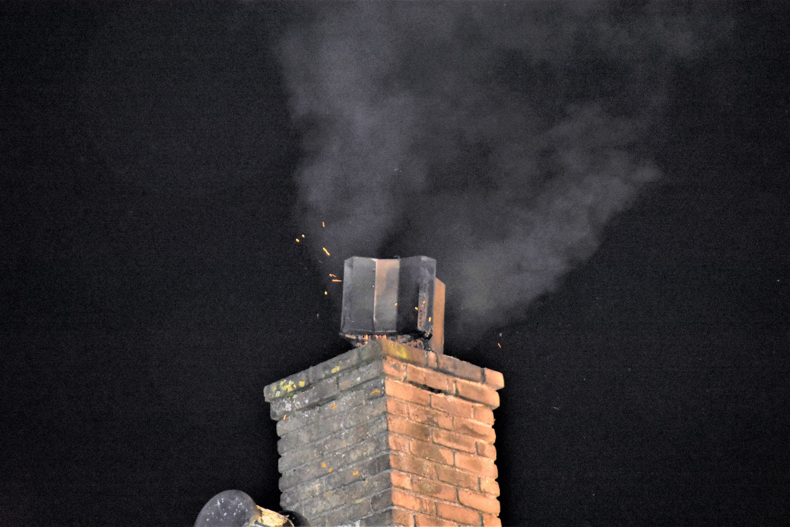Vonken in de nacht door schoorsteenbrand