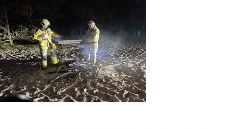 Kampvuur in duinen met zand geblust