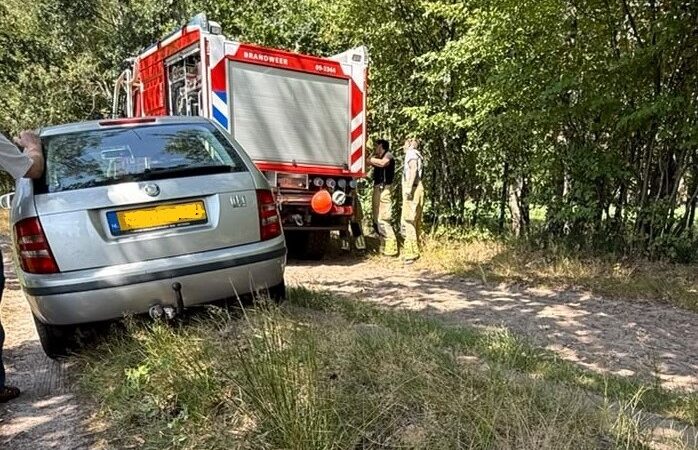 Brandweer trekt auto uit berm